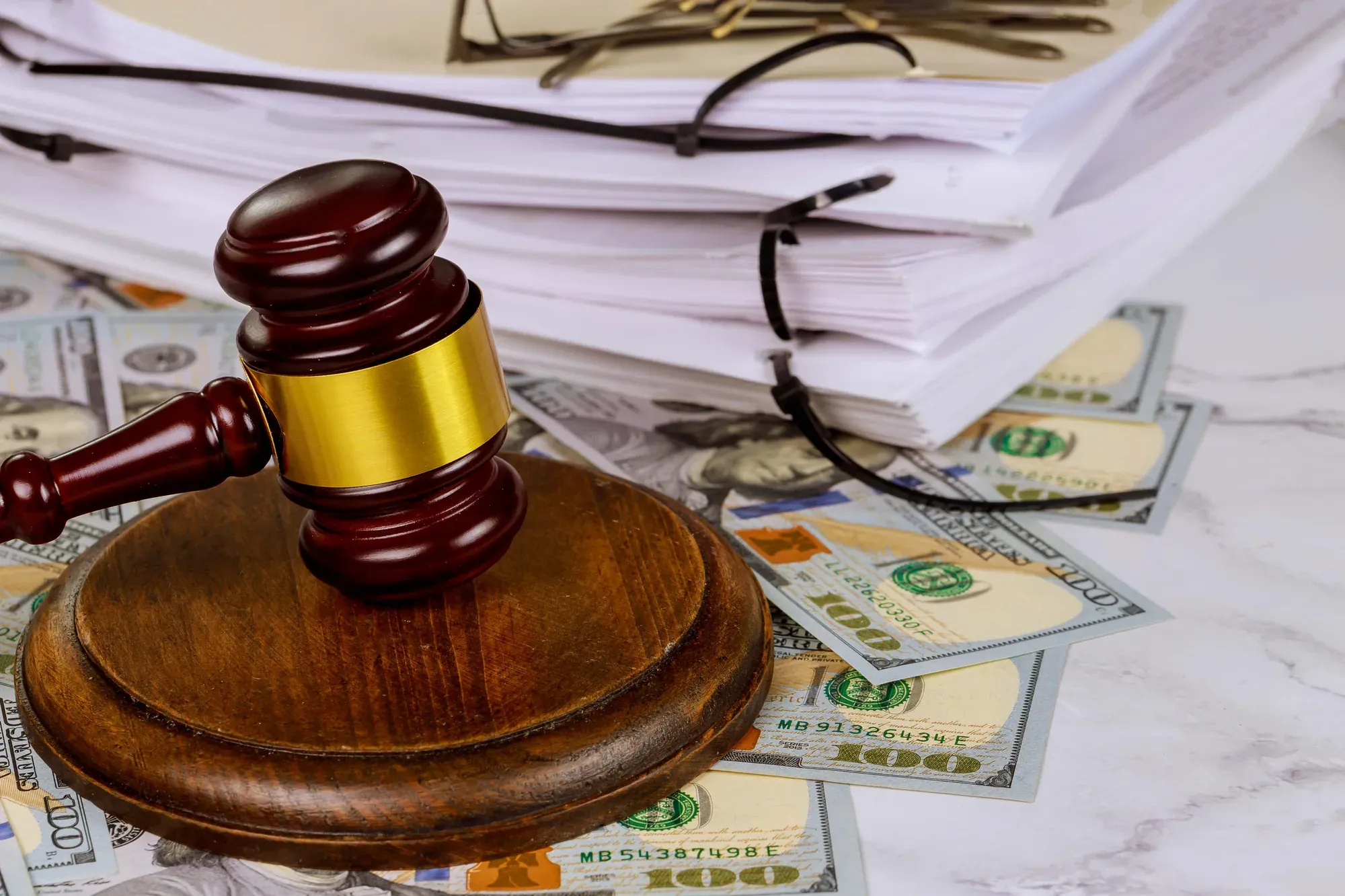 Mazo judicial sobre expedientes y billetes de dólar